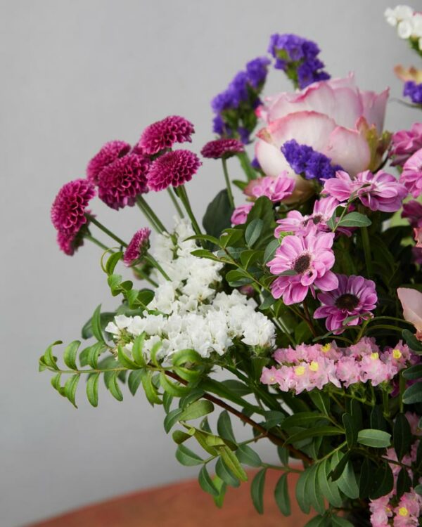 Bouquet Frutti di Bosco dettaglio di margheritine lilla, statice viola e rosa, verde di stagione